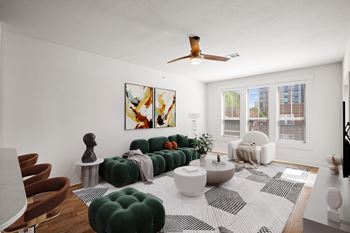 A living room with a green sofa and a white rug.
